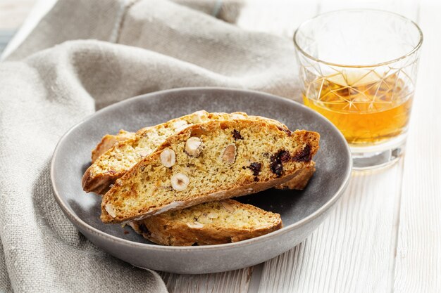 Biscoitos italianos em prato cinza e vinho doce Vin Santo.