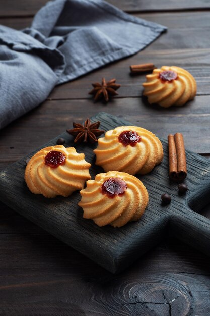 Biscoitos kurabye com geléia de frutas em um prato preto sobremesa deliciosa fundo escuro de madeira