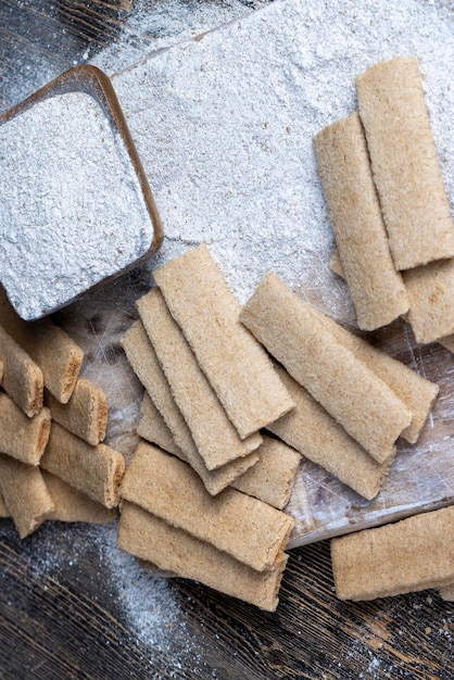 Biscoitos longos de trigo recheados com purê de frutas diferentes biscoitos com recheio de frutas na mesa com farinha