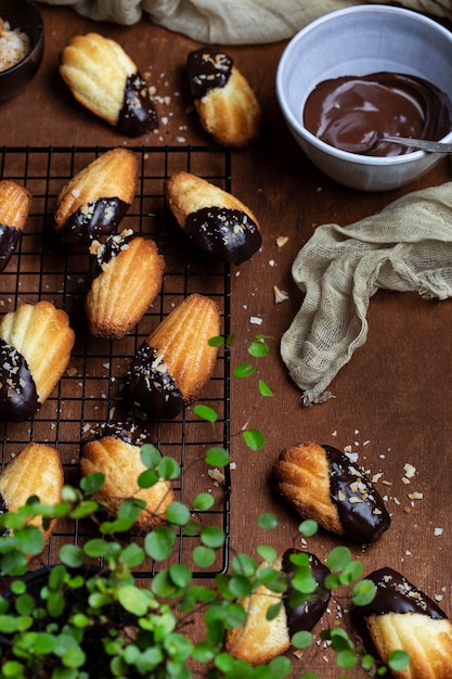 Biscoitos Madeleine com cobertura de chocolate e migalhas de coco