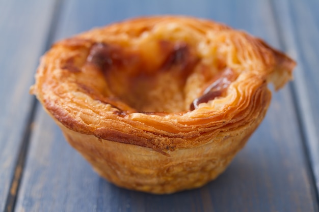 Biscoitos portugueses tradicionais pasteis de nata na superfície de madeira azul