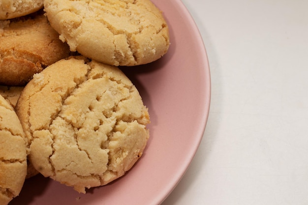 Biscoitos redondos caseiros no prato rosa com espaço de cópia