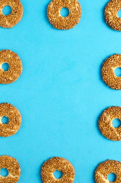 Biscoitos redondos com sementes de gergelim em um fundo azul brilhanteConfeitaria