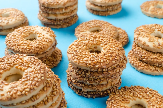 Biscoitos redondos com sementes de gergelim em um fundo azul brilhanteConfeitaria