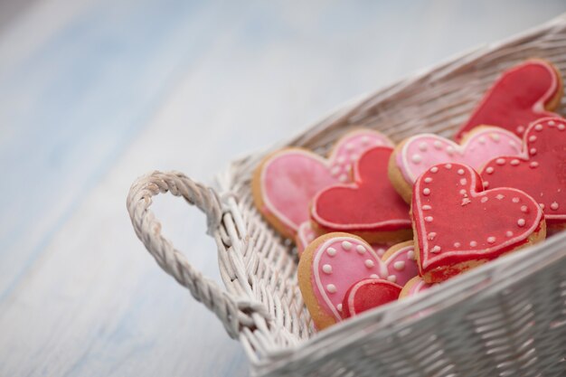 Biscoitos rosa em forma de coração em close-up de uma cesta de vime quadrada