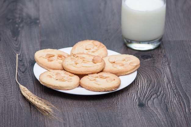 Biscoitos saborosos biscoitos com amêndoa e trigo na chapa de fundo de madeira com vidro