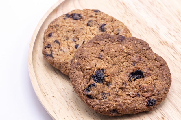 Biscoitos saborosos dos pedaços de chocolate no fundo da placa de madeira.