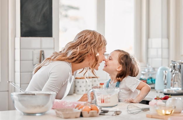 Biscoitos são feitos de manteiga e amor Foto de mãe e filha brincando na cozinha em casa