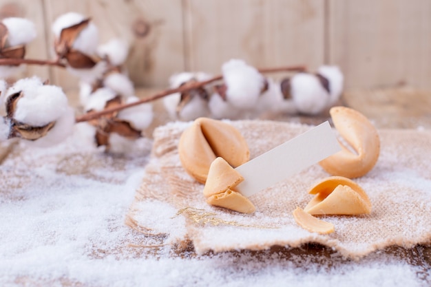 biscoitos tradicionais com desejos para o Natal e ano novo, em uma mesa de madeira e um galho com algodão