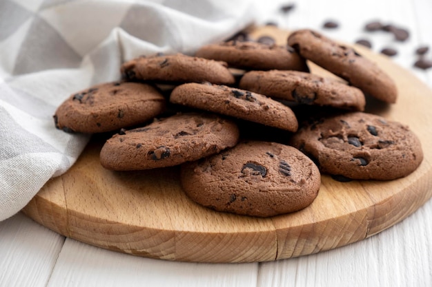 Biscoitos veganos caseiros de cereais na placa de madeira com toalha de cozinha Receita de biscoitos sem açúcar com passas e nozes Lanche de dieta vegana Lanche ou guloseima para chá ou café