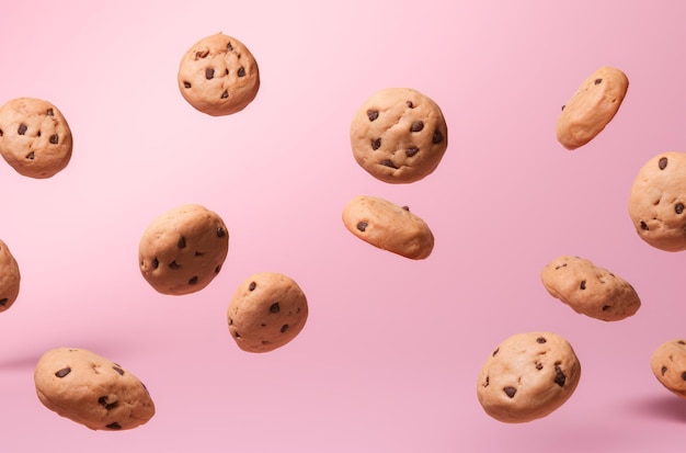 Foto biscoitos voando em torno de fundo rosa