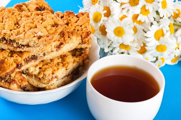 Biscoitos, xícara de chá e um buquê