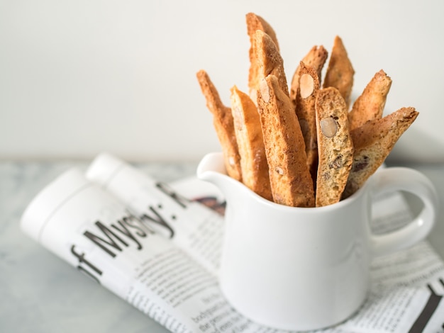 Biscotti (cantuccini) - postre italiano tradicional de la almendra en el primer blanco de la taza.