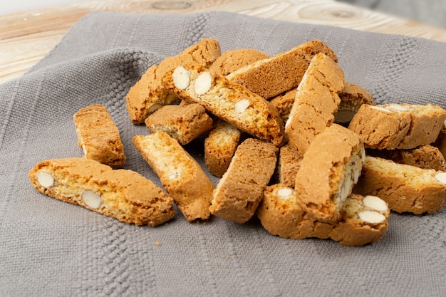 Biscotti di Prato auf grauem Serviettenhintergrund. Haufen von traditionellen italienischen Cantuccini-Nussplätzchen. Makroaufnahme von hausgemachtem Cantucci Shortbread mit Mandeln in einem Weidenkorb