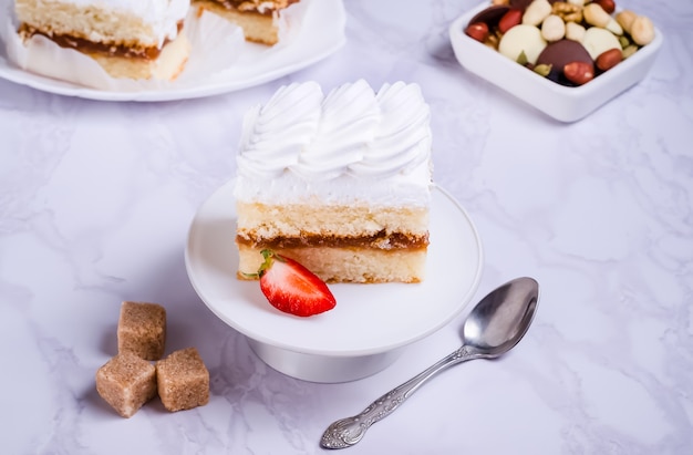 Biskuitkuchen mit Proteincreme auf weißem Teller