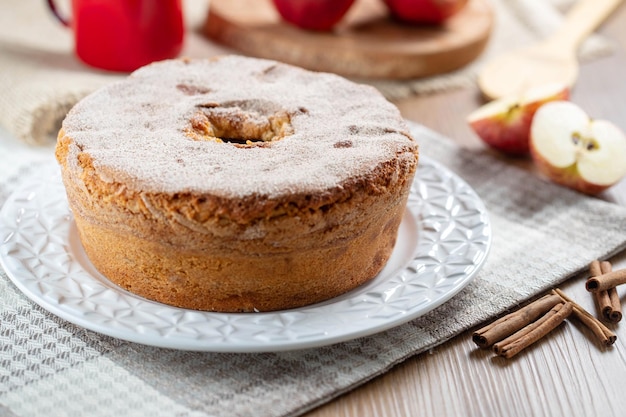 Biskuitkuchen oder Chiffon-Kuchen mit Äpfeln, die so weich und köstlich sind, in Scheiben geschnitten mit Zutaten Zimt Eier Mehl Äpfel auf Holztisch Hausbäckerei Konzept für Hintergrund und Tapete