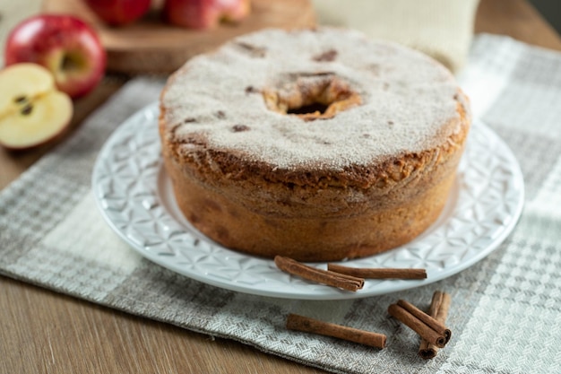 Biskuitkuchen oder Chiffon-Kuchen mit Äpfeln, die so weich und köstlich sind, in Scheiben geschnitten mit Zutaten Zimt Eier Mehl Äpfel auf Holztisch Hausbäckerei Konzept für Hintergrund und Tapete