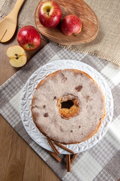 Biskuitkuchen oder Chiffonkuchen mit Äpfeln, die so weich und köstlich sind, in Scheiben geschnitten mit Zutaten Zimteier Mehläpfel auf Holztisch Hausbäckereikonzept für Hintergrund und Tapete Ansicht von oben