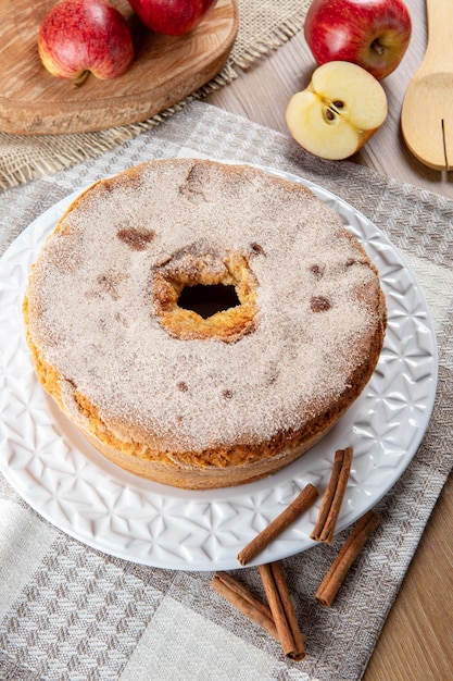 Biskuitkuchen oder Chiffonkuchen mit Äpfeln, die so weich und köstlich sind, in Scheiben geschnitten mit Zutaten Zimteier Mehläpfel auf Holztisch Hausbäckereikonzept für Hintergrund und Tapete Ansicht von oben