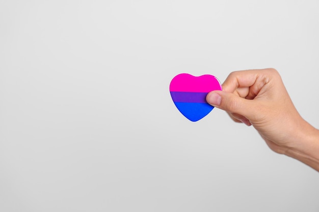 Bissexualidade Comemora o Dia e o mês do orgulho LGBT Conceito LGBTQ ou LGBTQIA Mão segurando a forma de um coração rosa roxo e azul para a comunidade Gay Lésbica Bissexual Transgênero Queer e Pansexual