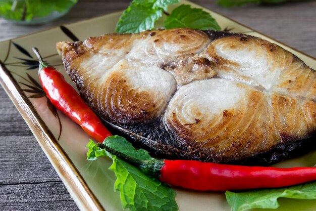 bistec de caballa rey en fondo de madera pescado frito