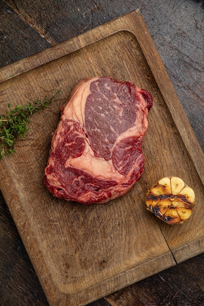 bistec de carne cruda en una tabla de madera en un restaurante premium