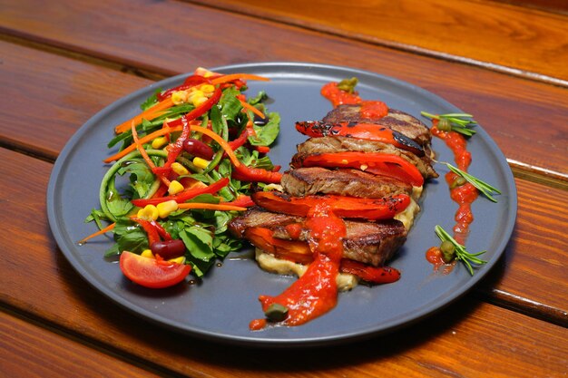 bistec de carne con ensalada patatas fritas y salsa en el plato Concepto de alimentos y verduras