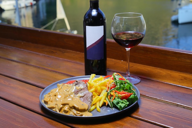 bistec de carne de res con ensalada patatas fritas y salsa de mostaza en el plato Concepto de comida