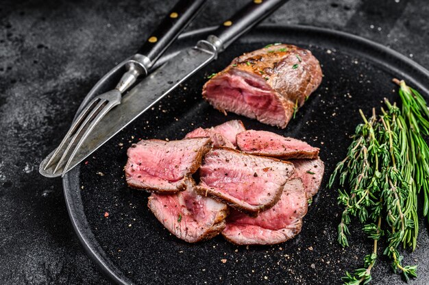 Bistec de carne de solomillo de ternera a la parrilla y en rodajas en un plato