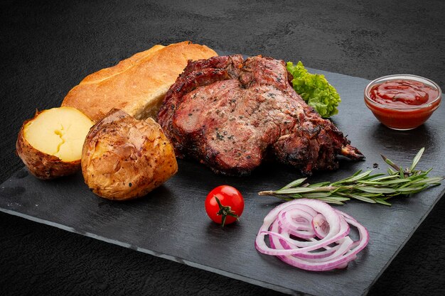 Bistec de cerdo a la parrilla con matnakash de papas al horno y salsa roja Servido en un plato de piedra