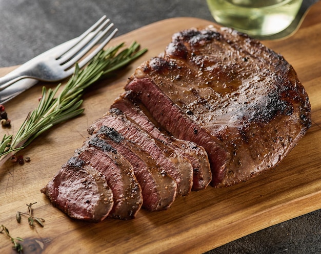 Bistec de corazón de ternera a la parrilla con pimienta en una tabla de madera