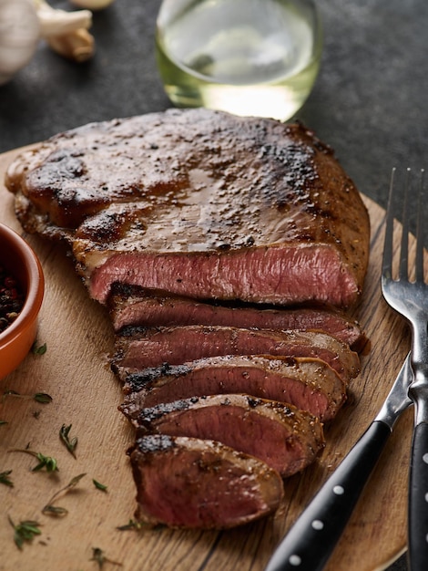 Bistec de corazón de ternera a la parrilla con pimienta en una tabla de madera