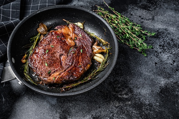 Bistec de costilla asado, chuletón de carne de vacuno en una sartén