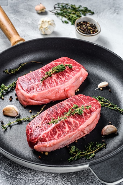 Bistec crudo de hoja superior en una sartén