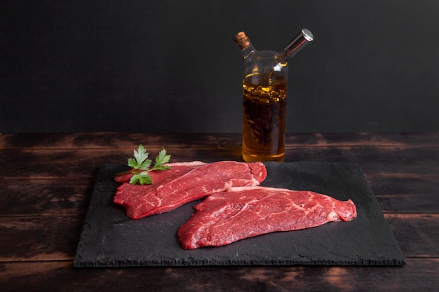 Bistec crudo de ternera marmolada en botella de pizarra con aceite vegetal y vinagre balsámico