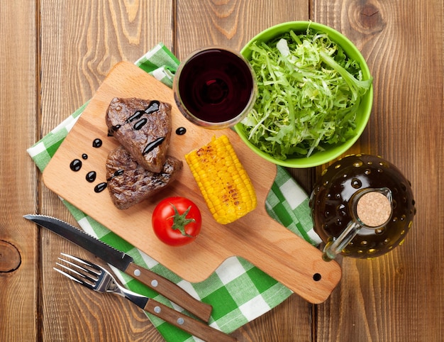 Bistec con ensalada de maíz a la parrilla y vino tinto