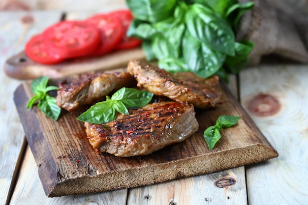 Bistec jugoso a la plancha sobre una tabla de madera