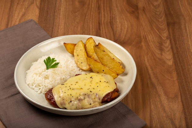 Bistec a la parmesana con arroz y patatas asadas Plato típico brasileño