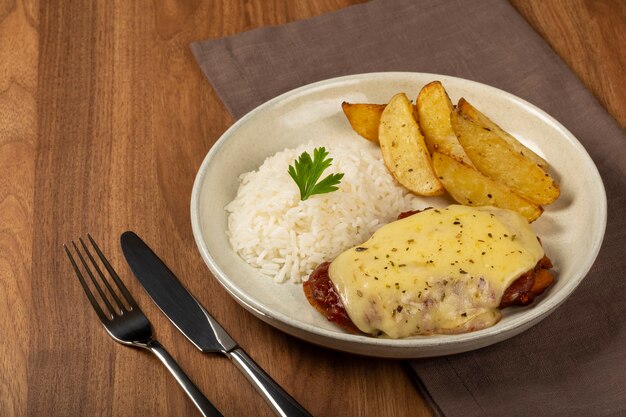 Bistec a la parmesana con arroz y patatas asadas Plato típico brasileño