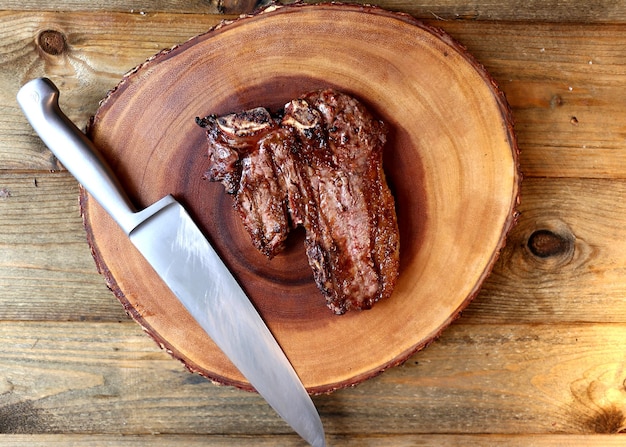 Bistec a la parrilla con hueso y dos tipos de carne Sobre fondo de madera