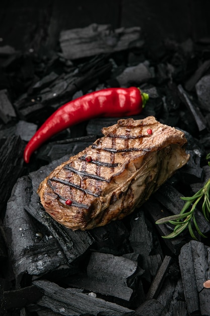 Bistec a la parrilla sobre un fondo de carbón negro