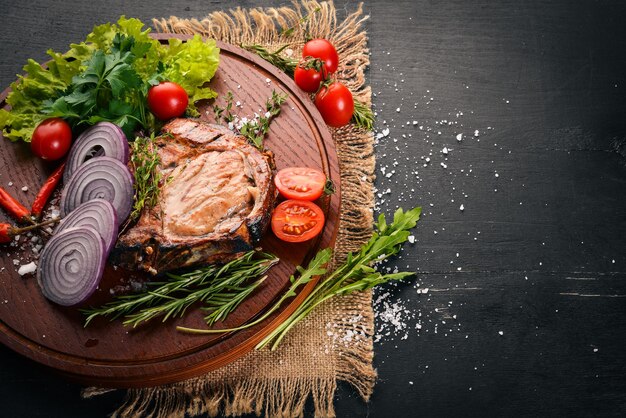 Bistec a la parrilla con verduras Carne de ternera de cerdo Sobre un fondo de madera Vista superior Espacio libre para texto