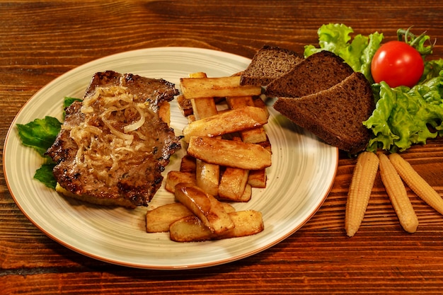 Bistec a la plancha con patatas fritas caseras crujientes al horno decoradas con pan negro