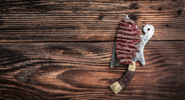 Bistec a la plancha sobre cuchillo de carnicero. banner, lugar de receta de menú para texto, vista superior.