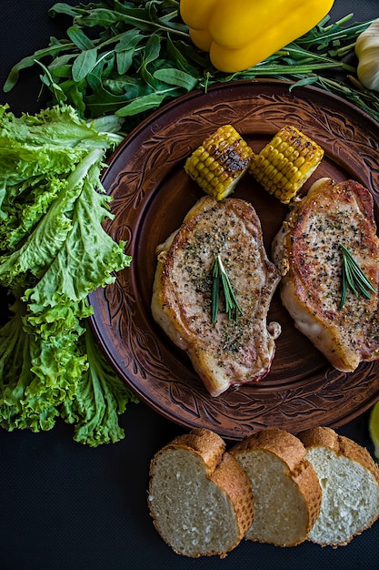 Bistec a la plancha con verduras en una sartén decorada con romero.