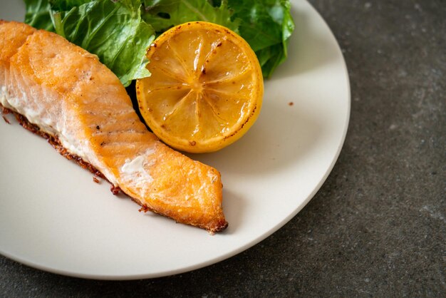 bistec de salmón frito casero con limón y vegetales - estilo de comida saludable