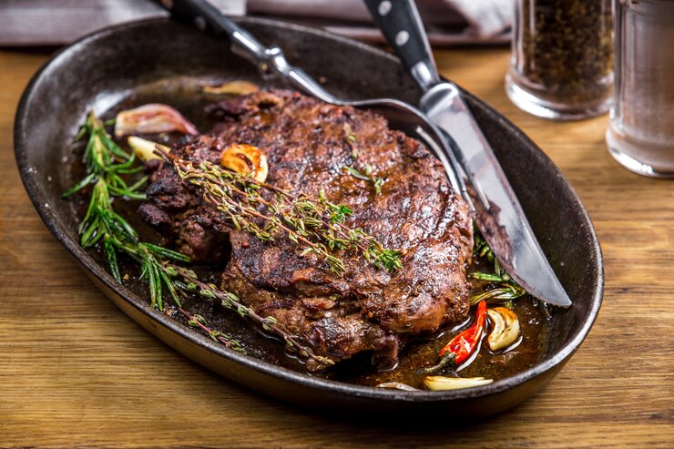 Foto bistec saludable y magro a la parrilla a medio cocer y verduras con vaso de whisky y una especia en un pub o taberna rústica. peinado de alimentos