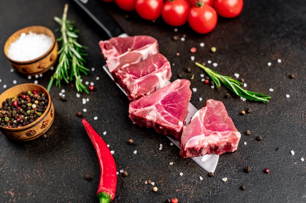 Bistec T-Bone crudo en un cuchillo sobre una mesa de piedra