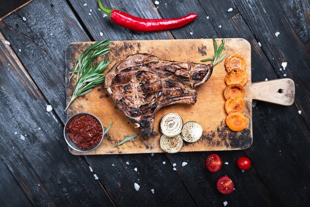 Bistec de tamaño mediano sobre una tabla de cortar, jugosa carne a la parrilla.