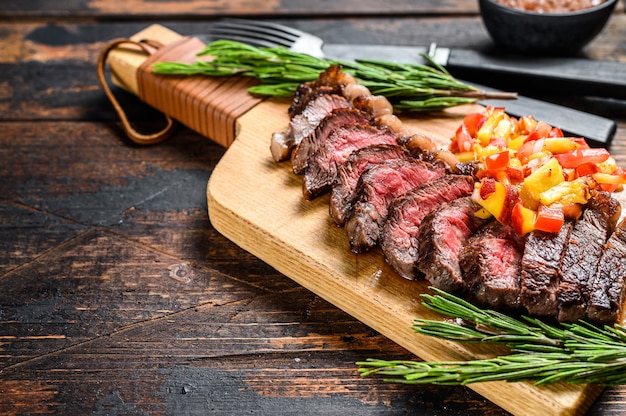 Bistec de tapa de rampa a la parrilla sobre una tabla para cortar